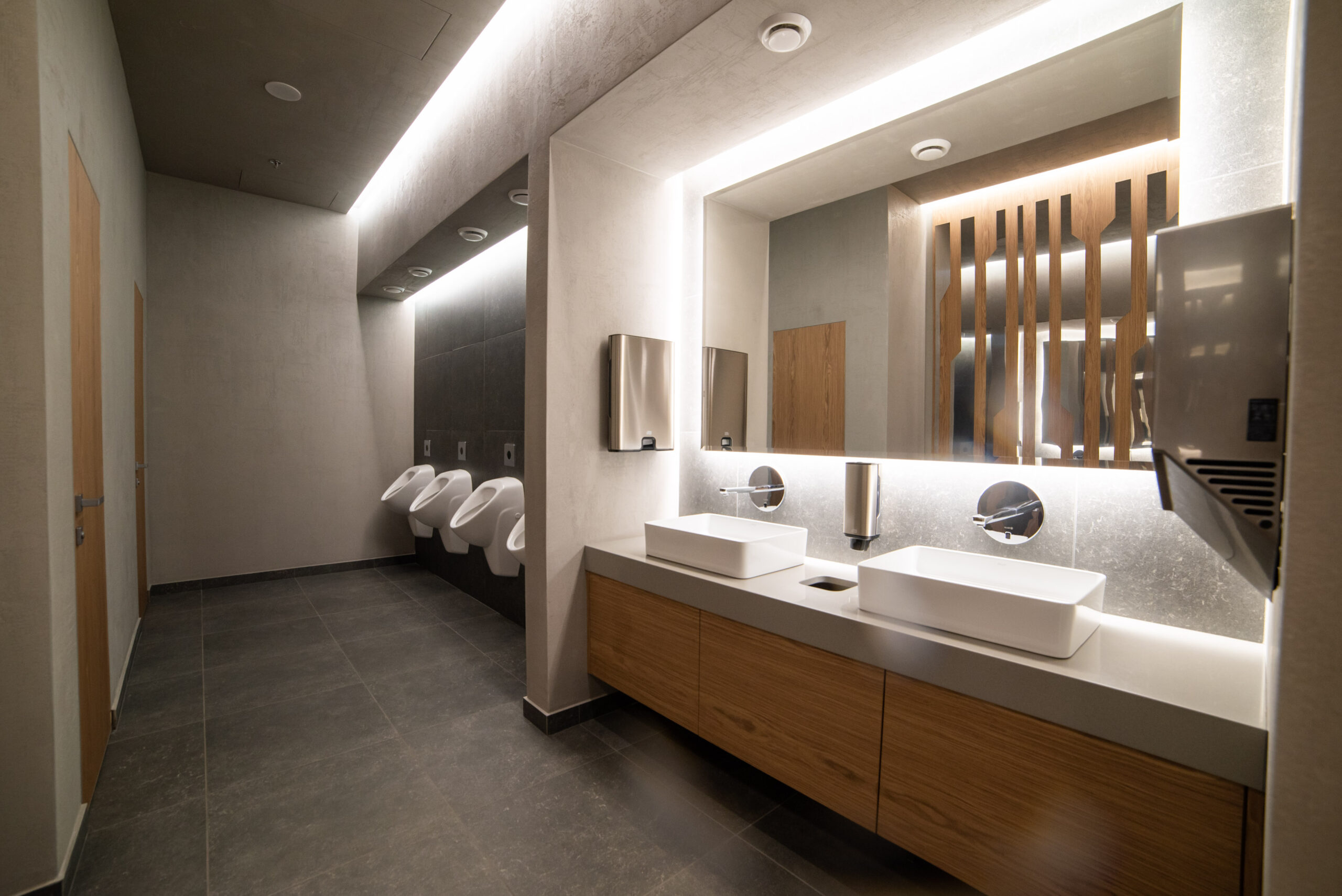 Modern commercial restroom with sinks and urinals for commercial plumbing and remodeling projects