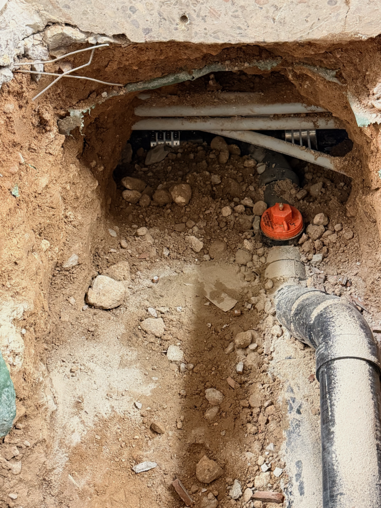 Excavated floor area and underground piping during a commercial restaurant floor sink installation
